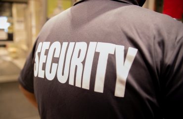 Rear view of a security guard in uniform patrolling in a commercial building.